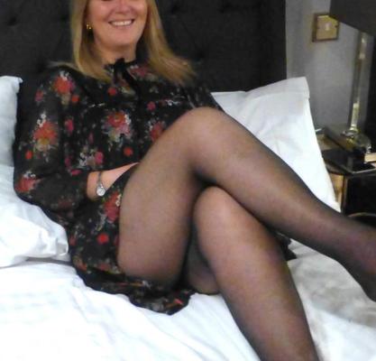 Ma femme dans une mini-robe montrant beaucoup de jambes, je serre des collants noirs